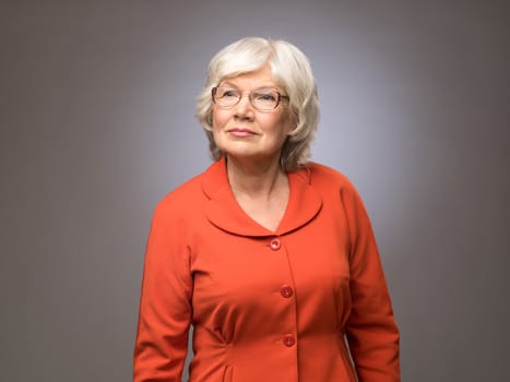 Senior lady in eyeglasses on gray background