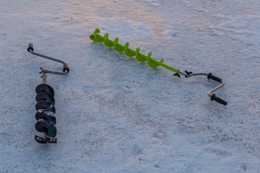 Fishing ice auger at dawn fishing drill ice beautiful sky