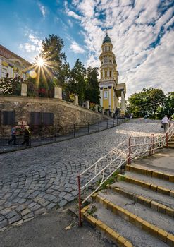 Uzhgorod, Ukraine - Jun 11, 2017: people go uphill to the Greco Catholic cathedral. everyday life in the central part of the beautiful old down in the morning