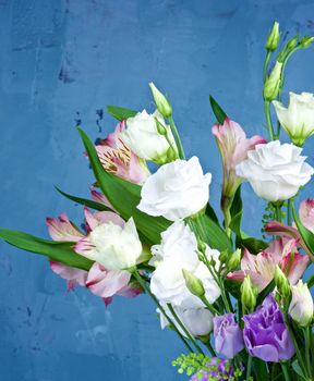 Elegant Flowers Bouquet with White and Purple Lisianthus, Alstroemeria and Decorative Green Stems closeup on Blue Textured background
