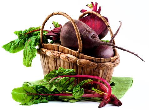 Arrangement of Full Body, Half and Young Sprouts with Green Beet Tops in Wicker Basket on Napkin isolated on White background