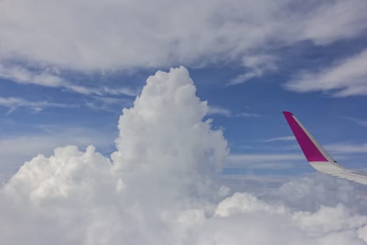 View from airplane.  The wing of an airplane and amazing white clouds at blue sky