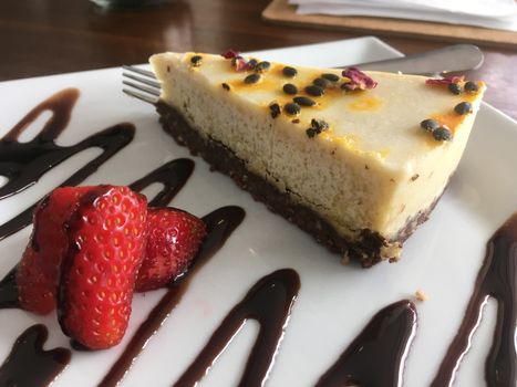 AIP Autoimmune Paleo or healthy eating choices.  Slice of cashew milk cheesecake on a plate in a wellness organic cafe. Gluten free dairy free