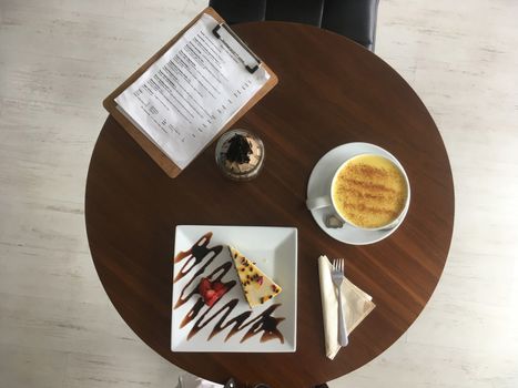 Before Shot Top view looking down on a table served with organic cashew milk cheesecake and golden turmeric latte.