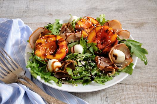 Salad with dried ham, grilled nectarine, mozzarella and arugula