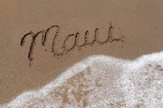 The Word Maui Written Into the Sand With Sea Foam