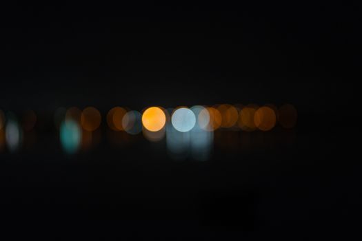 abstract defocused  city lights in distance on dark night sky background