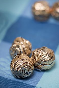 Pile of sweet round chocolate candies for christmas celebrations on a table cloth.