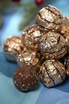 Pile of sweet round chocolate candies for christmas celebrations on a table cloth.