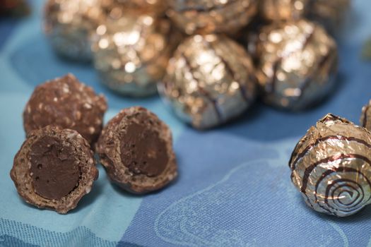 Pile of sweet round chocolate candies for christmas celebrations on a table cloth.