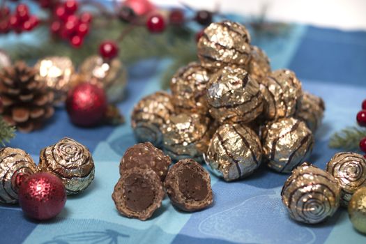 Pile of sweet round chocolate candies for christmas celebrations on a table cloth.