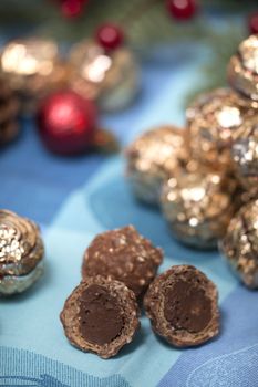 Pile of sweet round chocolate candies for christmas celebrations on a table cloth.