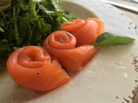 Smoked salmon rolled rosette on a plate in a cafe