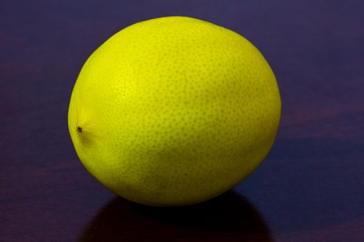 unpeeled  lemon fruit placed on the wooden  kitchen table