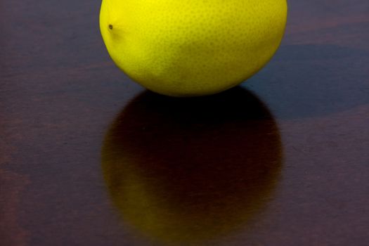 unpeeled  lemon fruit placed on the wooden  kitchen table