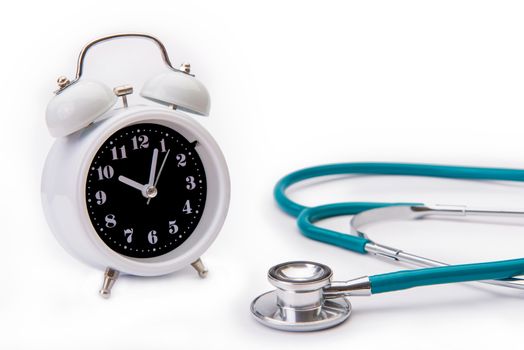 Retro alarm clock with medical instruments stethoscope isolate on white backgound.