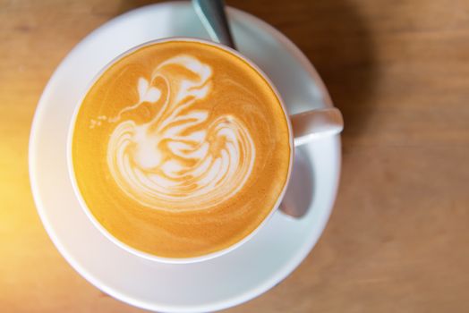 latte art coffee or cappuccino on wooden table background.