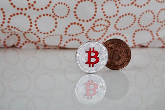 Cryptocurrency physical silver bitcoin coin and brass bitcoin on the white scene.