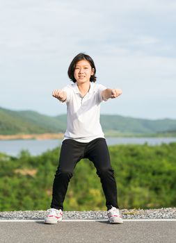 Fitness and lifestyle concept - Young asian woman short hair doing exercising outdoor and warm up preparing for jogging