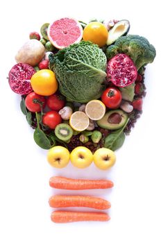 Light bulb made of fruits and vegetables over a white background