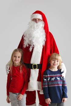 Portrait of Two Children and Santa Claus on gray background