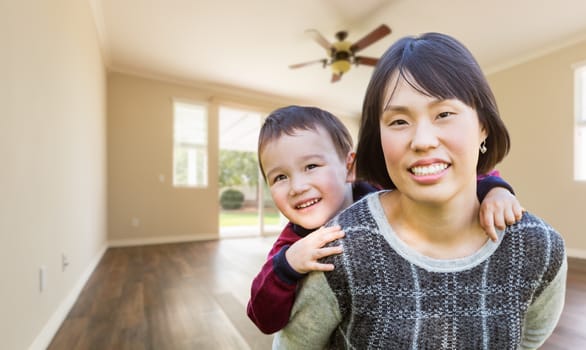 Chinese Mother and Mixed Race Child Inside Empty Room Of New House.