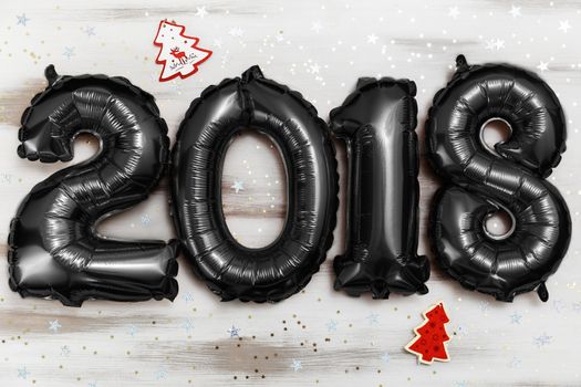 Bright black balloons figures 2018, New Year Balloons with glitter stars on white wood table background. Christmas and new year celebration