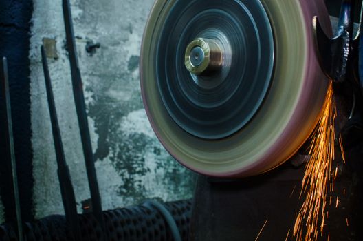 Industrial grinder showers sparks while working with metal.