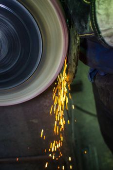 Industrial grinder showers sparks while working with metal.