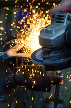 Industrial grinder showers sparks while working with metal.
