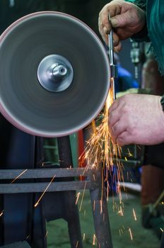 Industrial grinder showers sparks while working with metal.