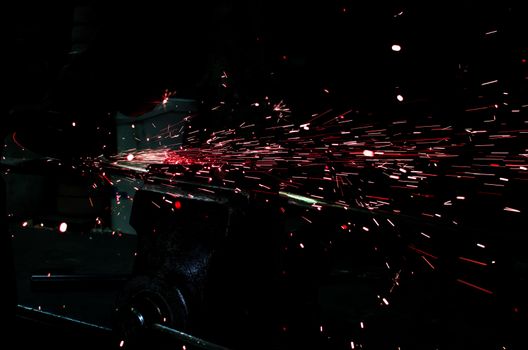 Industrial grinder showers sparks while working with metal.