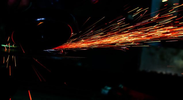 Industrial grinder showers sparks while working with metal.