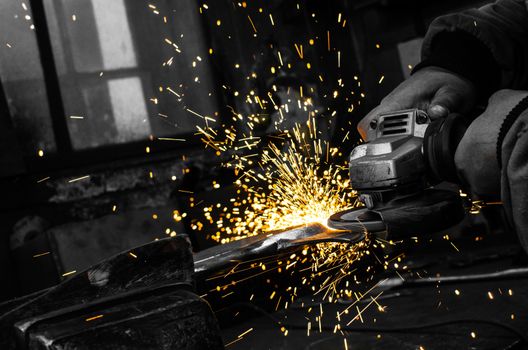 Industrial grinder showers sparks while working with metal.