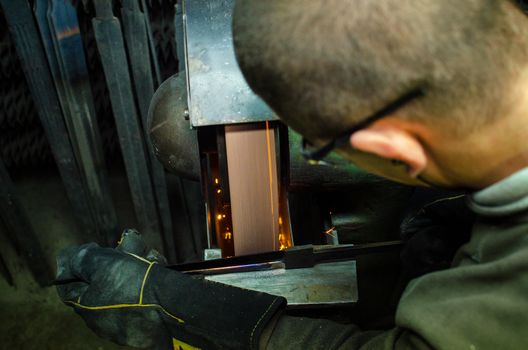 Industrial grinder showers sparks while working with metal.