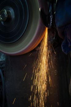 Industrial grinder showers sparks while working with metal.