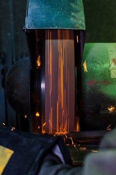 Industrial grinder showers sparks while working with metal.