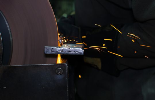 Industrial grinder showers sparks while working with metal.