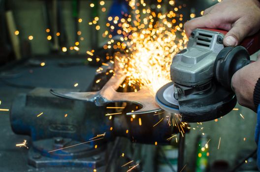 Industrial grinder showers sparks while working with metal.