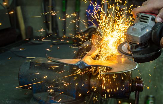 Industrial grinder showers sparks while working with metal.