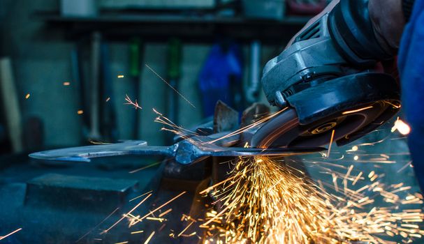 Industrial grinder showers sparks while working with metal.