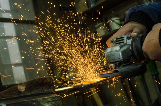Industrial grinder showers sparks while working with metal.
