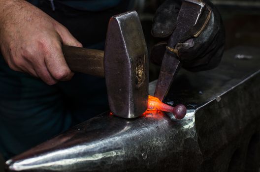 Blacksmith at work, hit with a hammer by a hot metal on the anvil.
