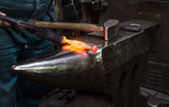 Blacksmith at work, hit with a hammer by a hot metal on the anvil.