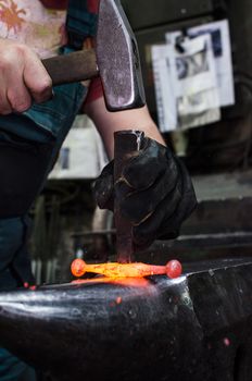 Blacksmith at work, hit with a hammer by a hot metal on the anvil.