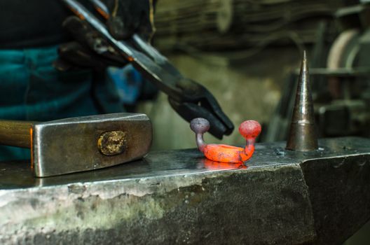 Blacksmith at work, hit with a hammer by a hot metal on the anvil.