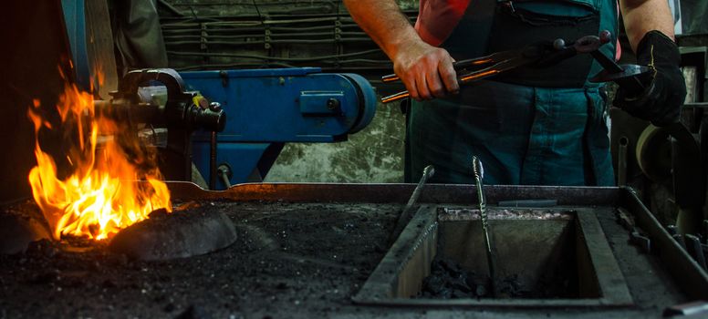 Blacksmith at work, hit with a hammer by a hot metal on the anvil.