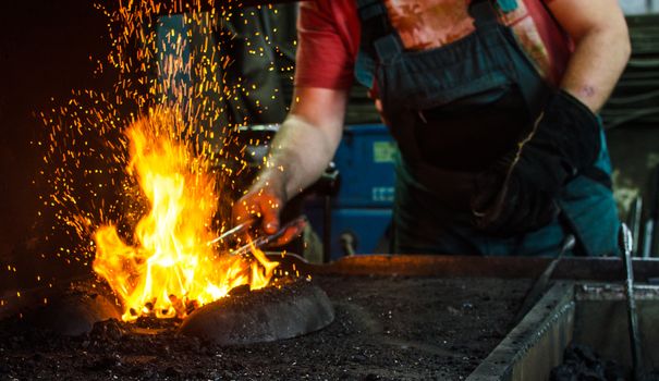 Blacksmith at work, hit with a hammer by a hot metal on the anvil.