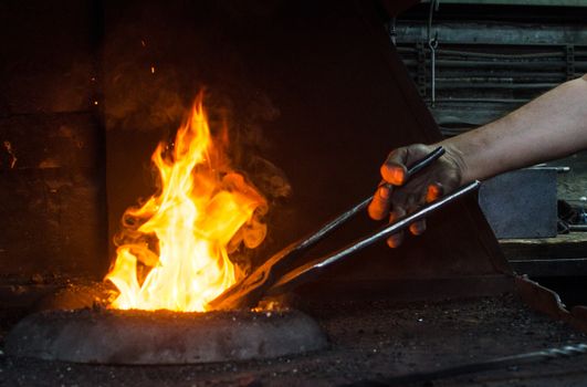 Blacksmith at work, hit with a hammer by a hot metal on the anvil.