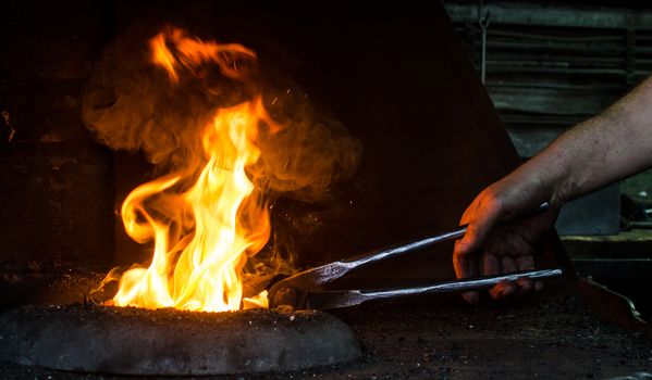 Blacksmith at work, hit with a hammer by a hot metal on the anvil.